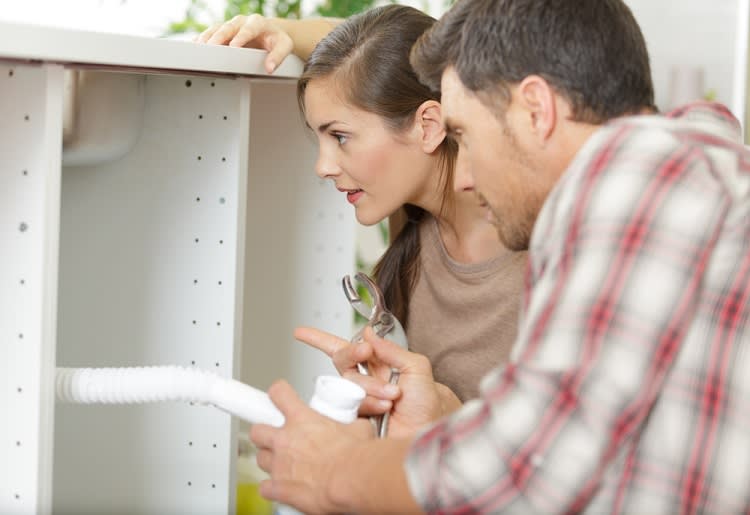 Couple trying to repair broken sink