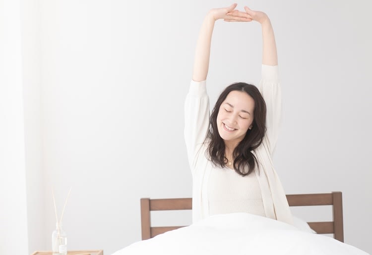 10 Steps to Connect With Your Spirit Guides for Divine Guidance A woman stretching her arms on a bed